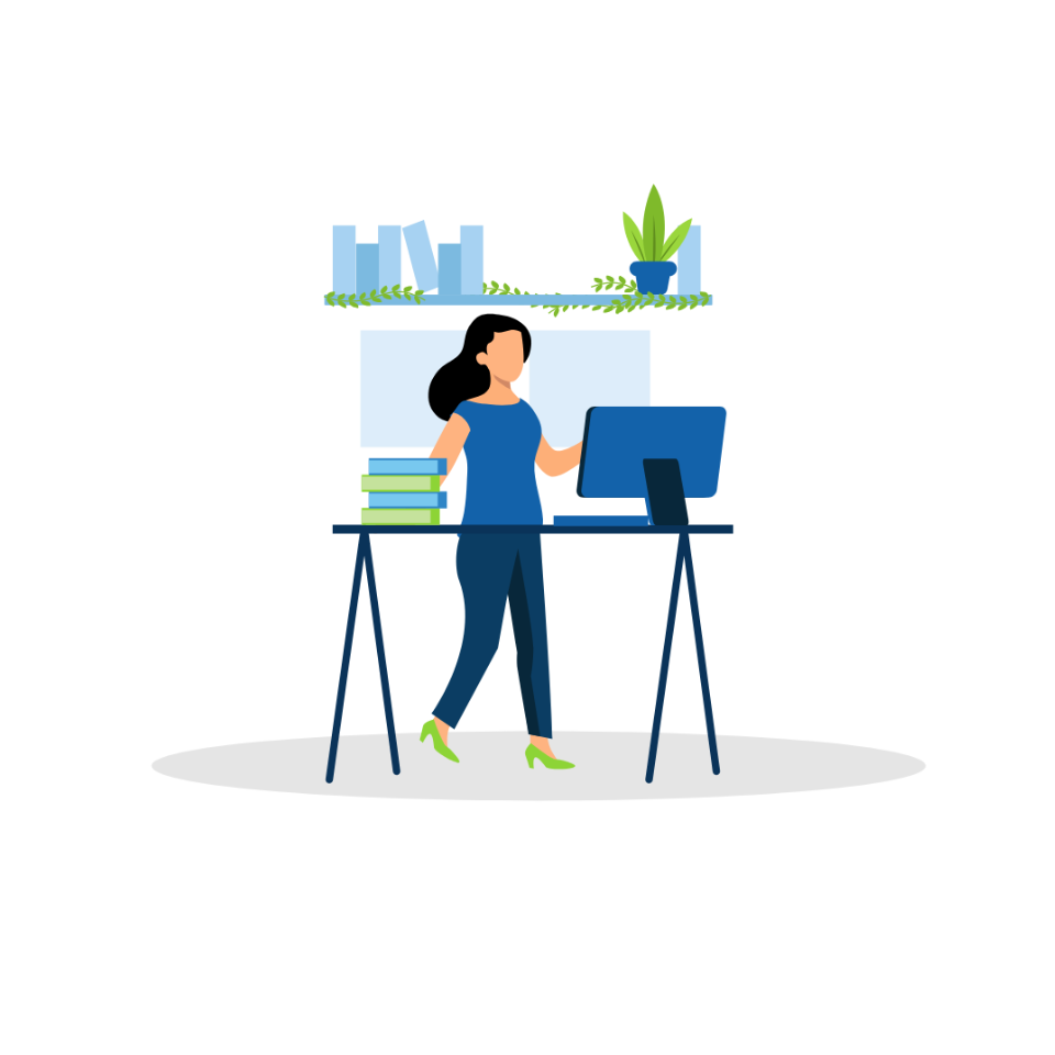 Woman standing at a desk working on a desktop computer.